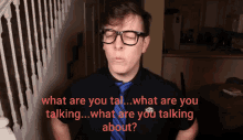 a man wearing glasses and a blue tie says what are you talking