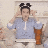 a man wearing a headband is sitting on a couch with a laptop and a tablet .