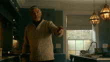 a man in a sweater is pointing at something