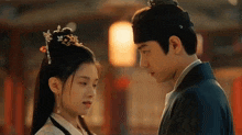 a man and a woman are looking into each other 's eyes in a room .