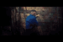 a man standing in front of a brick wall