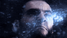 a close up of a man 's face with a blue light coming out of it