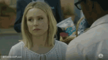 a woman in a white shirt is looking at a man in a white shirt .