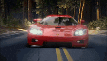 a red sports car is driving down a road