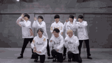 a group of young men are posing for a picture while wearing white sweatshirts .