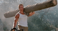 a man in a white tank top is carrying a large log on his shoulders