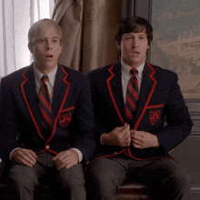 two men wearing school uniforms with a shield on the sleeve