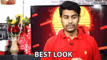 a man in a red shirt says best look in front of a tv