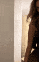 a woman is standing in a hallway wearing a black dress .
