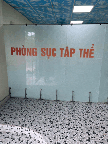 a glass wall with the words phòng suc tap the written in red