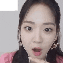 a close up of a woman wearing headphones and making a funny face .