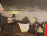 a man is holding a gun in front of a couch .
