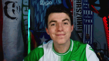a man wearing a green and white shirt with a zgio logo in the background