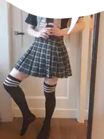 a person wearing a plaid skirt and black knee high socks