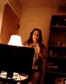 a woman is sitting in front of a lamp and a laptop