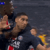 a soccer player wearing a qatar airways jersey is giving a high five