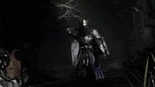 a man in a knight 's armor is standing in the dark holding a sword .