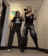 two women are dancing in a hallway and one has a shirt that says " my love we have young "