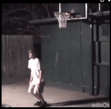 a boy is playing basketball in front of a basketball hoop that says inshot