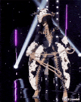 a woman in a cow costume is holding a lasso on stage .