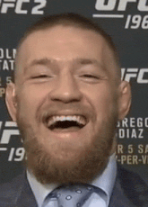 a close up of a man 's face with a beard smiling .