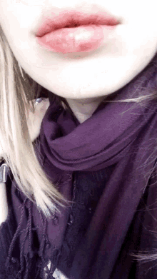 a close up of a woman wearing a purple scarf and lipstick