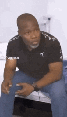 a man is sitting on a bed holding a cell phone and looking at the camera .