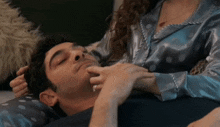 a woman is touching a man 's face with her finger