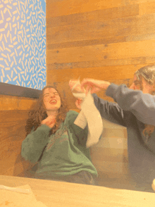 a girl wearing a green sweatshirt with the word eagles on it is fighting another girl
