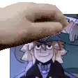 a hand is holding a cartoon character in front of a picture of a cartoon character .