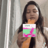 a woman is eating a banana next to a picture of a cd cover that says zeyn