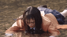 a girl in a school uniform laying in the water