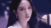 a close up of a woman wearing a white shirt and hoop earrings