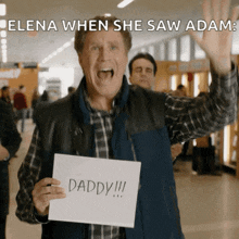 a man holds up a sign that says daddy on it