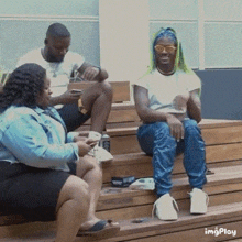 a group of people are sitting on a set of wooden steps with a gif that says imgplay