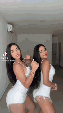 two women in white dresses are standing next to each other in a room with a tiktok watermark
