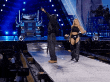 a man and a woman are on a stage with a microphone