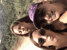 three women wearing sunglasses and a hat are posing for a picture together .