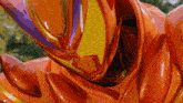a close up of an orange sculpture with a purple stripe