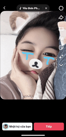 a girl with a teddy bear on her face has tears on her eyes