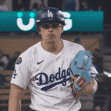 a man wearing a dodgers jersey holds a glove