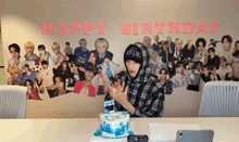 a man in a plaid shirt stands in front of a birthday cake