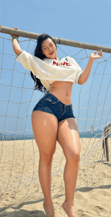a woman wearing shorts and a shirt that says navy is standing in front of a soccer net