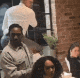 a group of people are sitting at a table in front of a window .
