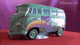 a toy van with a peace sign painted on it is on a red surface .