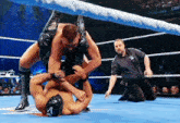a referee watches two men wrestle in a ring with the word grif on the corner