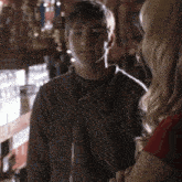 a man and a woman are standing in a bar