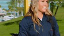 a woman wearing a blue jacket with the pack written on the back