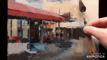 a painting of a red awning is being painted on a canvas