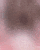 a blurred image of a person 's face with a pink background .